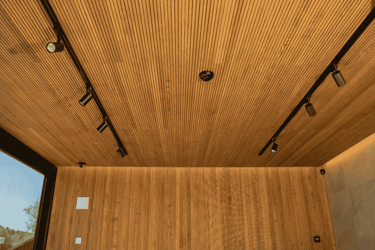 Thermo spruce wood ceiling panels in a modern interior with integrated lighting